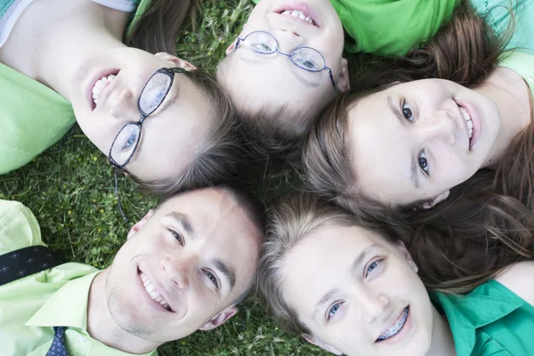 Broeders en zusters liggen in het gras — Stockfoto