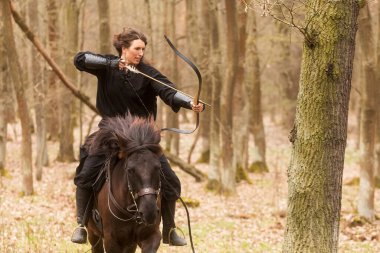 Oklu ve yaylı siyah elbiseli kadın.
