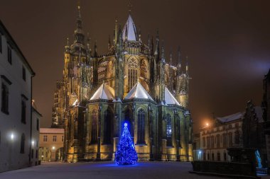 Gecenin karlı Prag şatosu, mavi Noel ağacı olan St. Vitus Katedrali