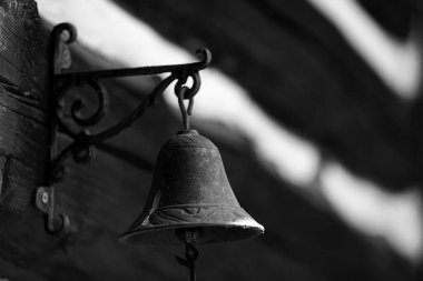 Tahta arka planda, duvarda çan var.