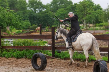 Kadın at sırtında yayla ateş ediyor.