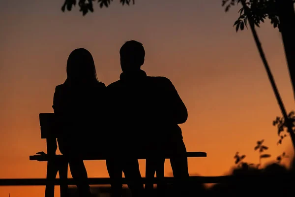 Silhouette Von Zwei Personen Auf Einer Bank Bei Sonnenuntergang — Stockfoto