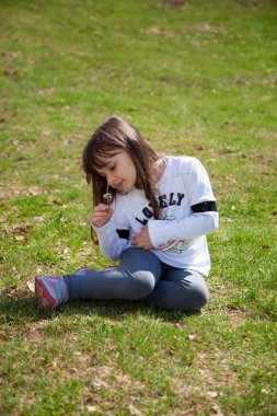 Çayırda oturan tatlı bebek kız