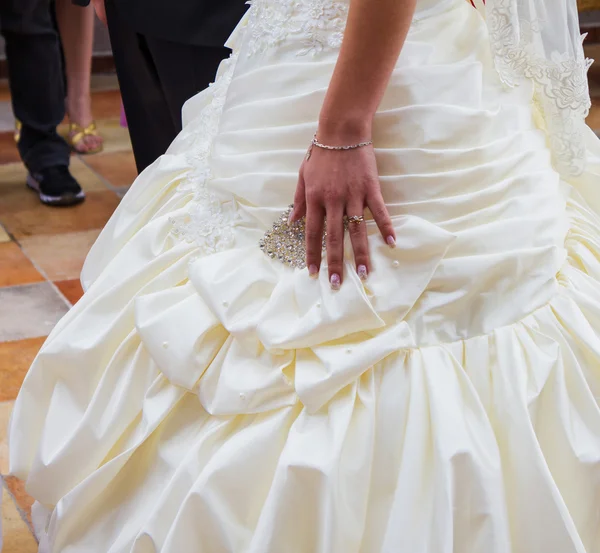 Jour du mariage. Main de mariée avec une alliance sur sa robe — Photo