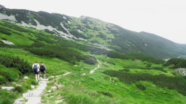 Yazın dağlarda yayan gezen ve güzel manzaraya hayran olan güzel bir çift güzel gölü görmek için yavaşça aşağı iniyor.. 