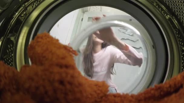 Wanita muda ibu rumah tangga yang melakukan pekerjaan rumah tangga rutin menemukan pakaian yang dikunyah di mesin cuci setelah dicuci, dia terkejut dengan kekecewaan, penembakan terjadi dari dalam. — Stok Video