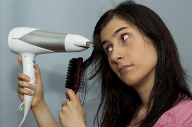 Young woman with hair dryer clipart