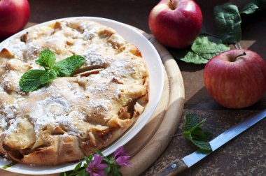 Elmalı ev yapımı kırmızı elmalı turta, ahşap arka planda nane şekeri. Kırsal biçim