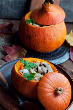 Kabak dolması doldurulmuş pirinç, havuç, biber ve mantar kahverengi tabakta maydanozla koyu kahverengi arka planda yuvarlak tahta üzerinde. Sağlıklı vejetaryen yemekleri. 