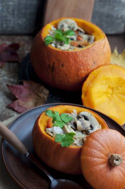 Kabak dolması doldurulmuş pirinç, havuç, biber ve mantar kahverengi tabakta maydanozla koyu kahverengi arka planda yuvarlak tahta üzerinde. Sağlıklı vejetaryen yemekleri. 