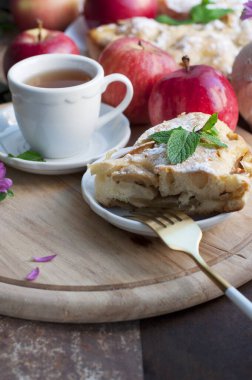 Elmalı ev yapımı kırmızı elmalı turta ve ahşap arka planda çiçek vazosu. Kırsal biçim