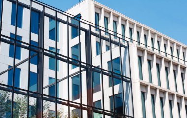 Mavi gökyüzüne karşı cam ve betondan yapılmış modern bir binanın parçası. Modern iş merkezi. Metin için yer