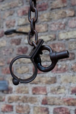 Antika tuğla duvarın karşısında antik metal kelepçeler.