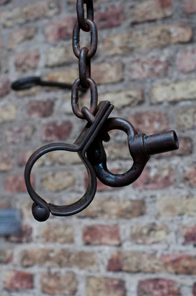 Antika tuğla duvarın karşısında antik metal kelepçeler.