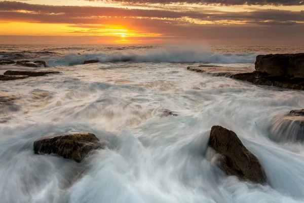 Incoming Waves Surge Sharp Rocks Creating Strong Frothy Flows Golden — Stock Photo, Image
