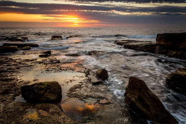 Slunce Mihotá Mraky Nad Skalnatým Pobřežím — Stock fotografie