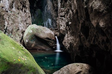 Etrafı yüksek kayalarla çevrili oldukça gizli bir kaya havuzuna küçük şelale.