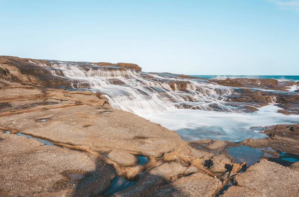 蜂蜜色の岩の上を流れる天の川の海のカスケード オーストラリア ストック画像