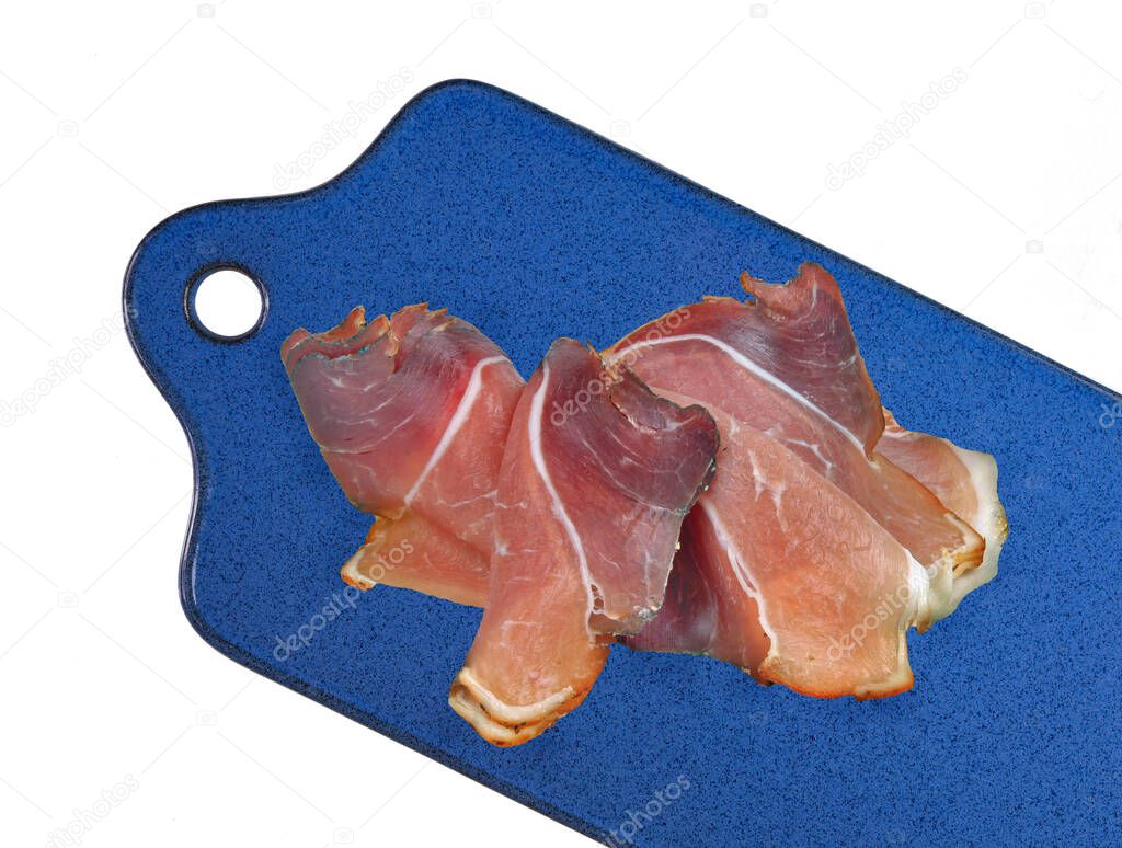 salami on a white plate with a knife, isolated on a wooden background