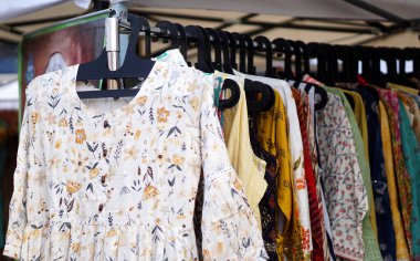 Kadın elbisesinin yakın plan görüntüsü vitrindeki askılara asılı.                                       