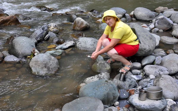 Female tourist washing utensil — Stock Photo, Image