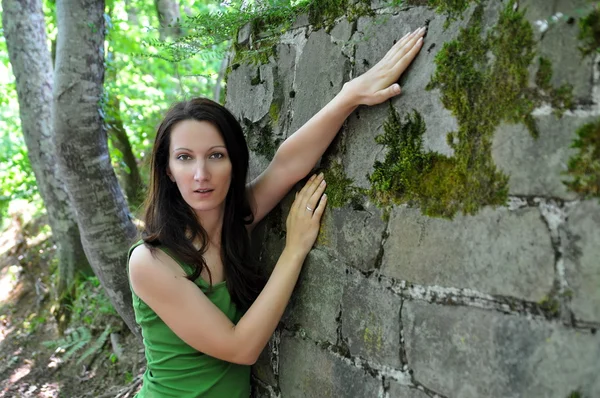 Donna vicino al vecchio muro di pietra — Foto Stock