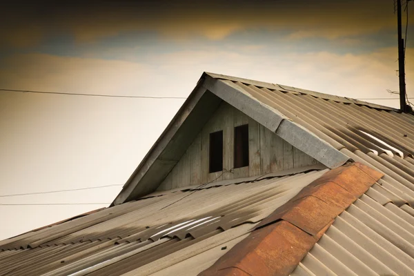 아름 다운 구름으로 집의 오래 된 지붕 — 스톡 사진
