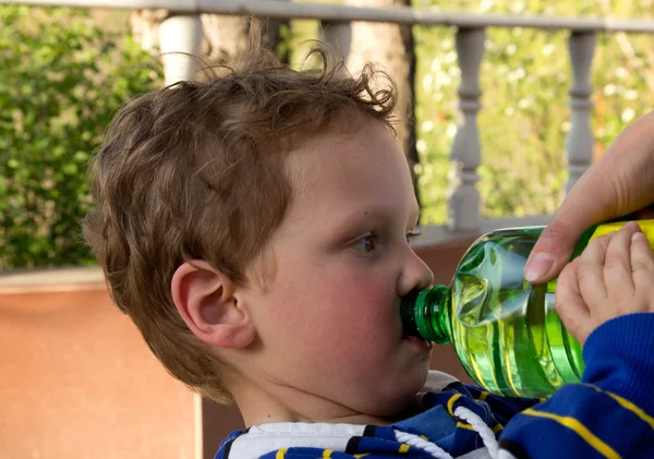 Chlapec pije vodu z láhve — Stock fotografie