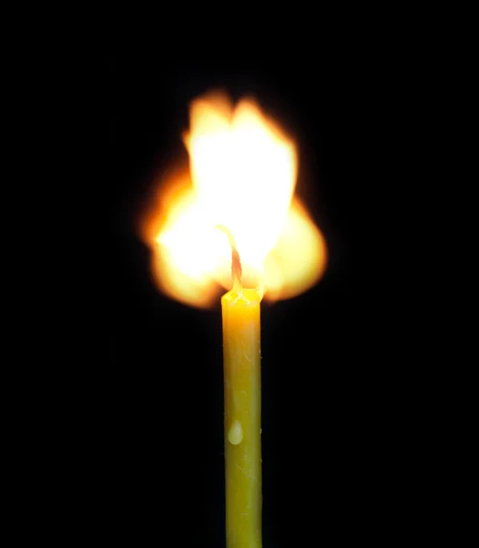 Brinnande ljus på en svart bakgrund — Stockfoto