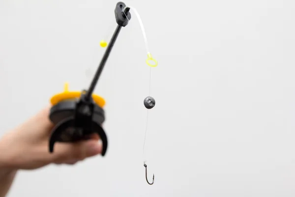 Fishing tackle in a hand on a white background — Stock Photo, Image