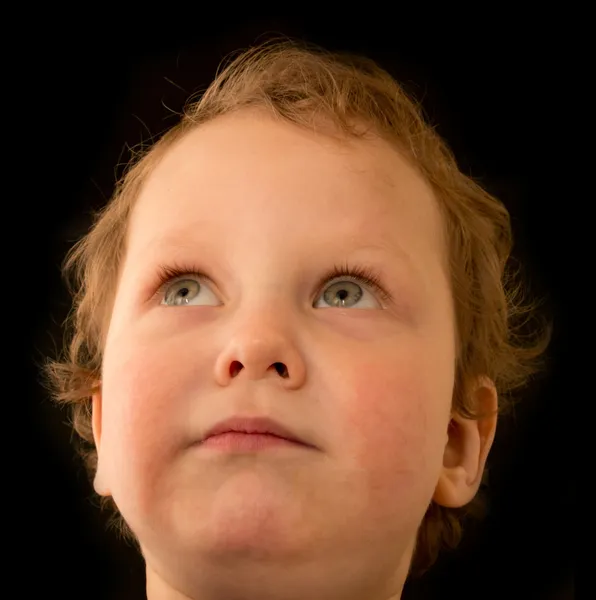 Un retrato de un niño sobre un fondo negro — Foto de Stock