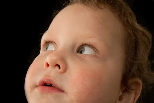 Een portret van een jongen op een zwarte achtergrond — Stockfoto