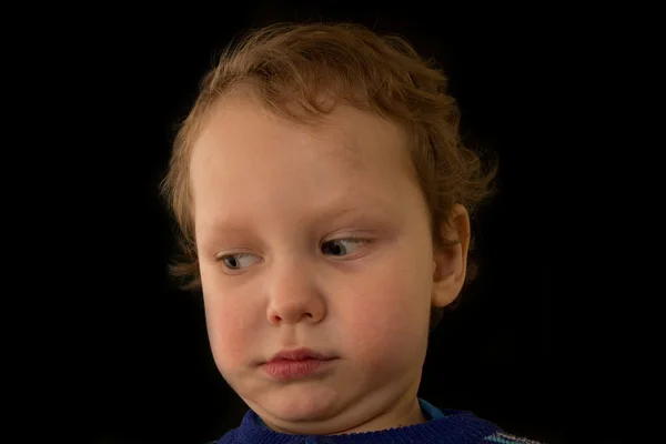 Um retrato de um menino em um fundo preto — Fotografia de Stock