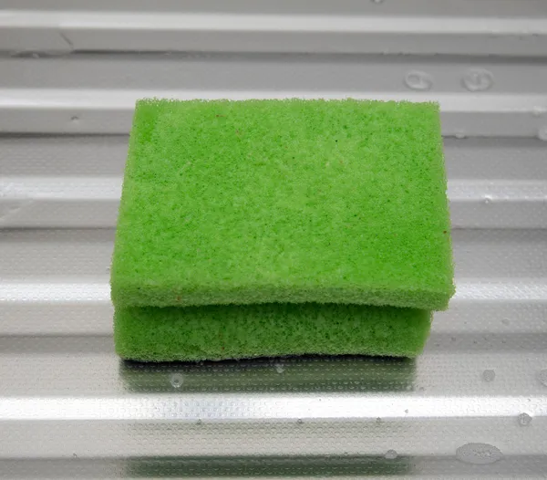 Éponge verte sur une surface métallique — Photo