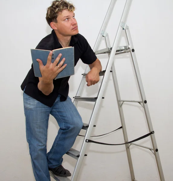 A man with a ladder and a book Stock Photo