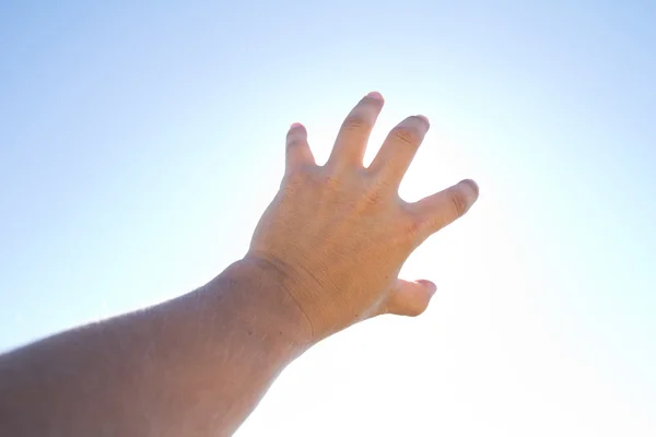 Die Hand des Mannes gegen den blauen Himmel — Stockfoto
