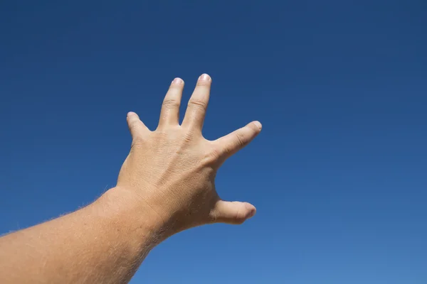 Mão do homem contra o céu azul — Fotografia de Stock