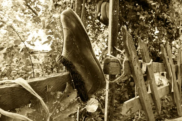 Old galoshes hanging on the fence — Stock Photo, Image