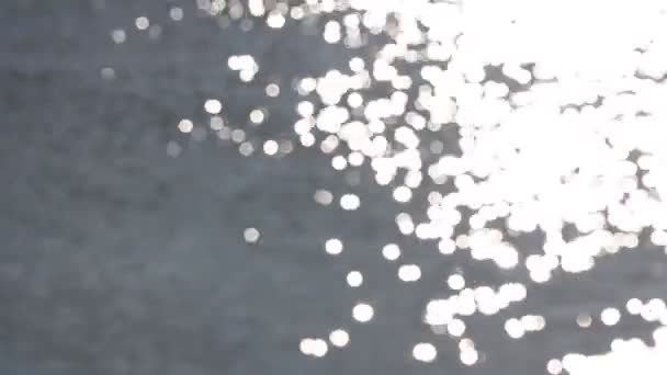 Mooie bokeh van de stralen van de zon op het water — Stockvideo