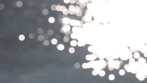 Mooie bokeh van de stralen van de zon op het water — Stockvideo