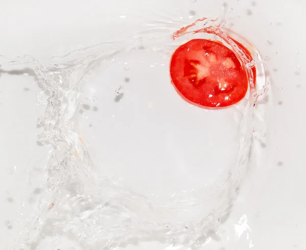 Tomat i vatten på vit bakgrund — Stockfoto