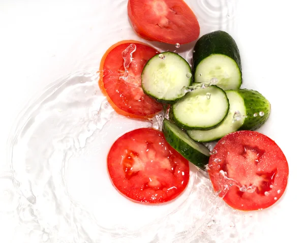 Gurke und Tomate in Wasser auf weißem Hintergrund — Stockfoto