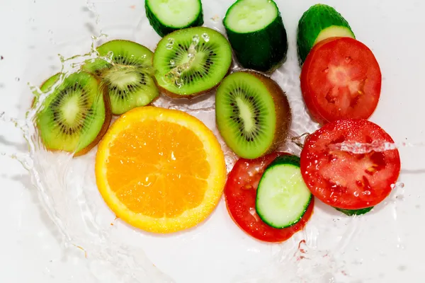 Frutas y verduras frescas en agua sobre un fondo blanco —  Fotos de Stock