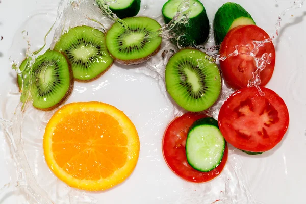 Frutta e verdura fresca in acqua su fondo bianco — Foto Stock