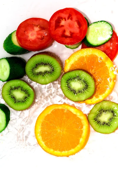 Frutas e legumes frescos na água sobre um fundo branco — Fotografia de Stock