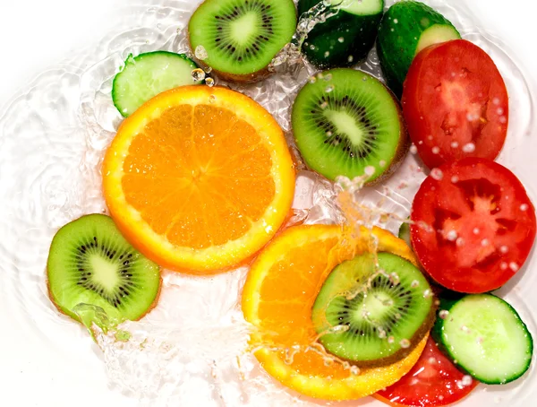 Frutas e legumes frescos na água sobre um fundo branco — Fotografia de Stock