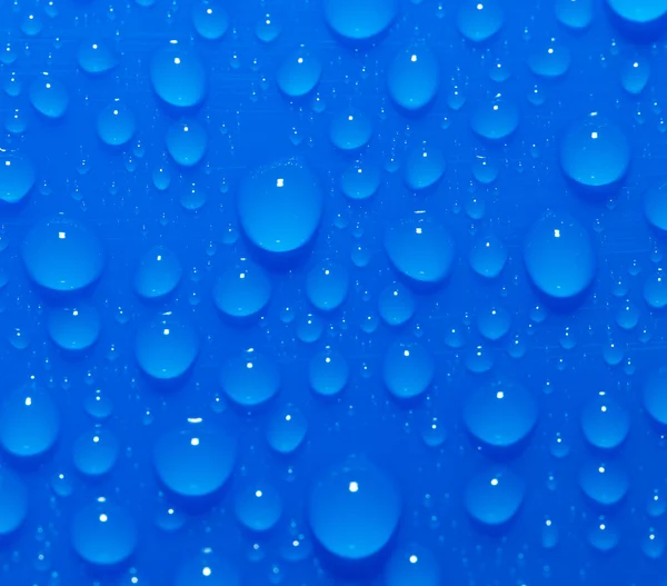 Kapky vody na modrém pozadí. makro — Stock fotografie