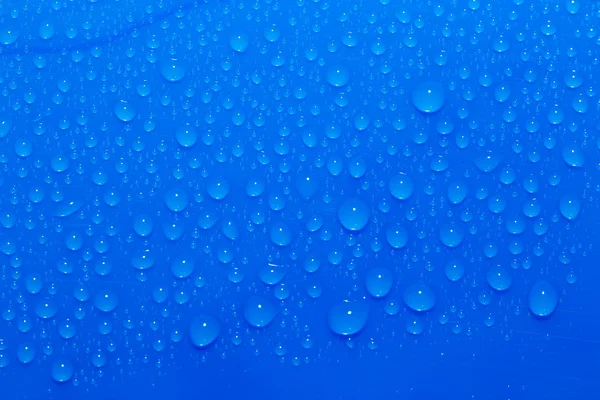 Gotas de agua sobre un fondo azul. macro — Foto de Stock