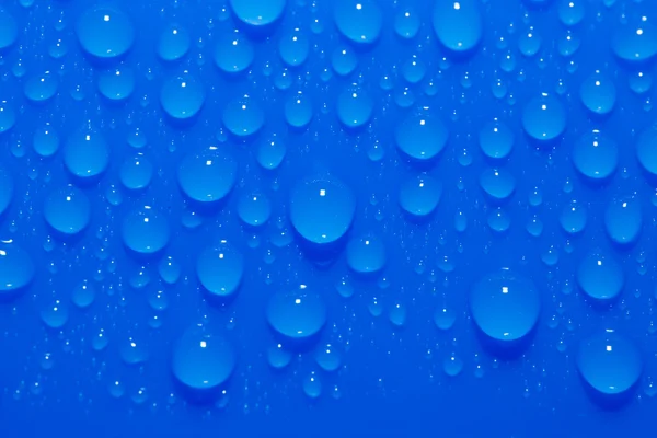 Gotas de agua sobre un fondo azul. macro — Foto de Stock