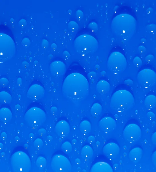 Gotas de água sobre um fundo azul. macro — Fotografia de Stock